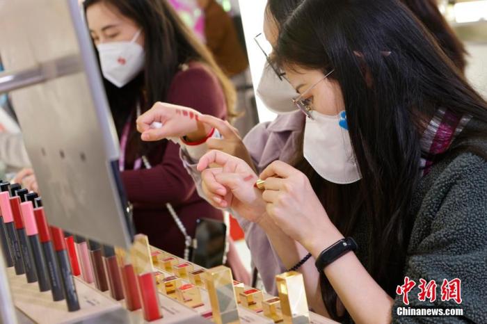 圖為女生正在體驗口紅產(chǎn)品。 殷立勤 攝