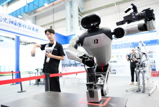 9月5日，在沈陽(yáng)的2025全球工業(yè)互聯(lián)網(wǎng)大會(huì)的展覽區(qū)現(xiàn)場(chǎng)，中國(guó)科學(xué)院沈陽(yáng)自動(dòng)化研究所的機(jī)器人工程師在調(diào)試具身智能操作系統(tǒng)。新華社記者 李鋼 攝